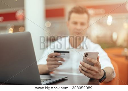 Man Using Smartphone And Laptop Computer For Online Shopping . Credit Card
