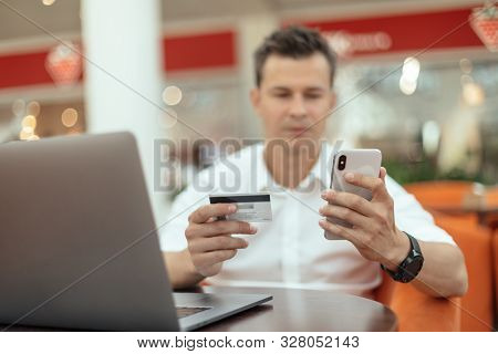Man Using Smartphone And Laptop Computer For Online Shopping . Credit Card