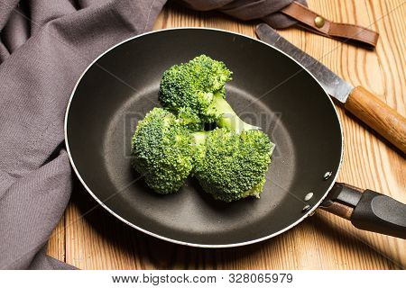 Brocoli In A Frying Pan On A Wooden Table
