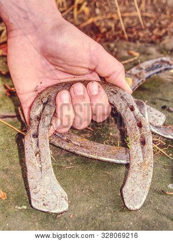 Woman Hand Hold Horseshoe. Silver Wornout Brushed Horseshoes Make Contrast Between Pink Skin Hand An