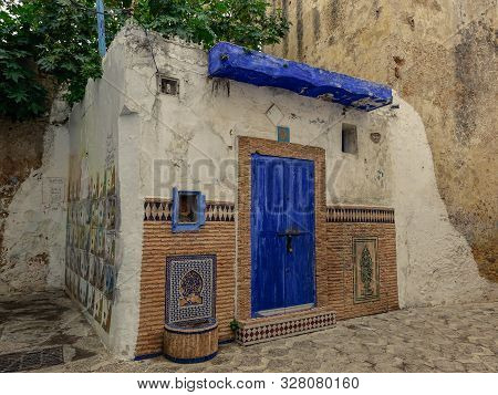 Assilah, Morocco, Africa - February 9, 2016: View Of A Small House With The Blue Door In The Narrow 