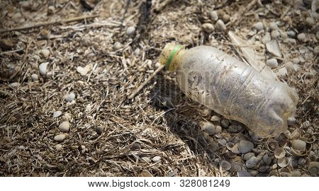 Beach Pollution. Dirty Indecomposable Plastic Bottle On Seaside, Copy Space