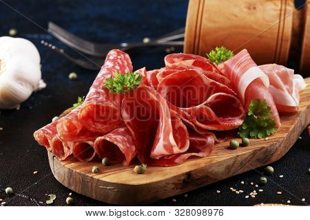Food Tray With Delicious Salami, Coppa, Crudo And Herbs. Meat Platter With Selection On Rustic Table