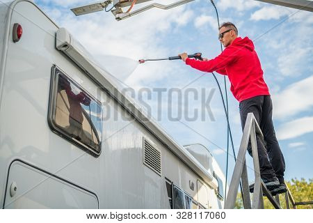 Post Season Rv Motorhome Camper Van Washing Using Pressure Washer. Caucasian Motor Coach Owner.