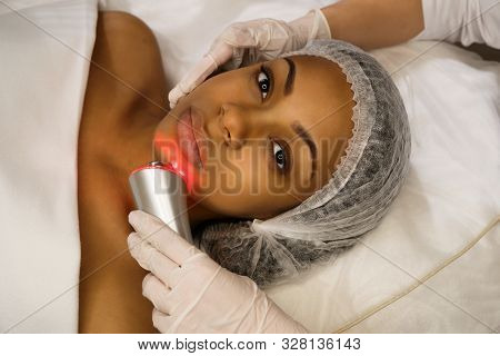 Ultrasound Chromotherapy. Hardware Cosmetology. Beautician Carries Out Procedure For Face Skin Rejuv