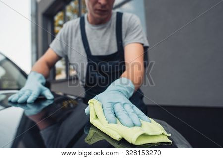 Selective Focus Of Car Cleaner Wiping Capote With Rag