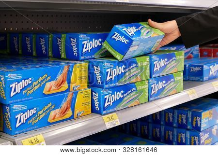 Coquitlam, BC, Canada - April 30, 2019 : Motion of woman buying ziploc zip bag inside Walmart store