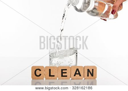 Cropped View Of Woman Pouring Water From Bottle In Glass Near Cubes With Clean Lettering Isolated On