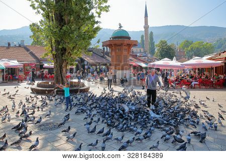 Sarajevo, Bosnia And Herzegovina - September 15, 2019: A Local Man Feeding Pigeons In Front Of The W