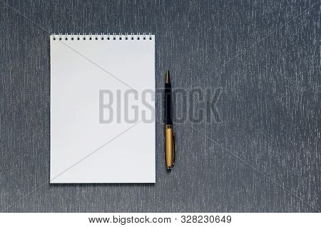 Flatlay with mockup. Office supplies, notebook with blank page for writing text, pen, on gray background with copy space