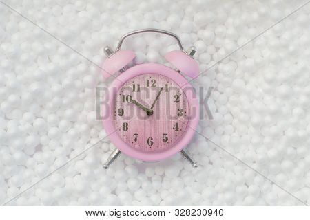 Top View Pastel Pink Retro Alarm Clock On Styro Foam Texture