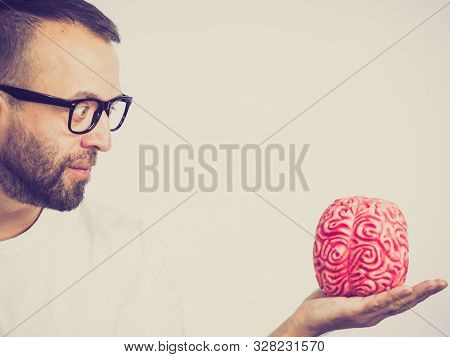 Adult Nerd Man Wearing Eyeglasses Looking At Human Brain Model. Thinking And Intelligence Conept
