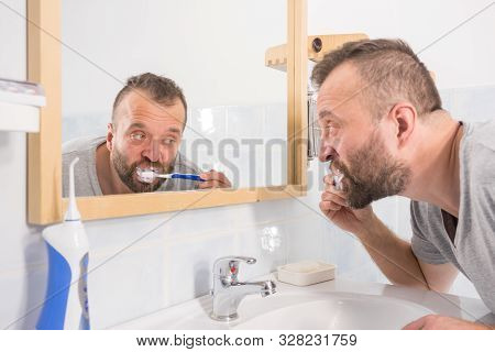 Man Brushing His Teeth In Bathroom