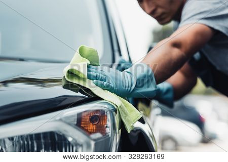 Selective Focus Of Car Cleaner Wiping Capote With Rag