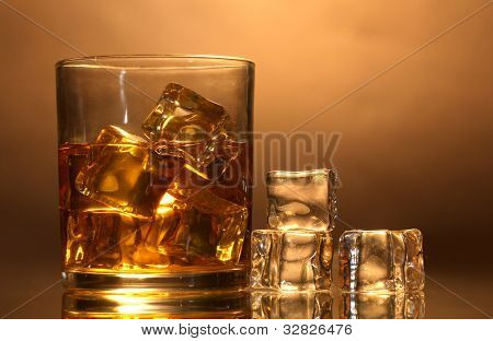 verre de whisky et de la glace sur fond marron