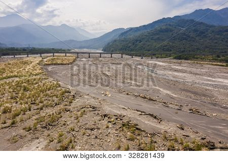landscape of golden miscanthus with mountain and river under sky