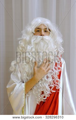 Portrait Of A Teenager With A White Beard And A Wig With Curls. Cosplay For A Costume Show Or Hallow