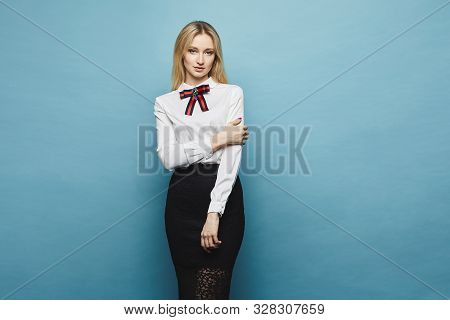 Beautiful Businesswoman In Midi Skirt And Blouse Posing At The Blue Background, Isolate. European Fe