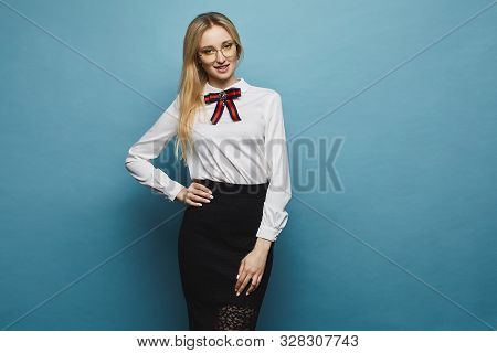 Beautiful Businesswoman In Midi Skirt And Blouse Posing At The Blue Background, Isolate. European Fe