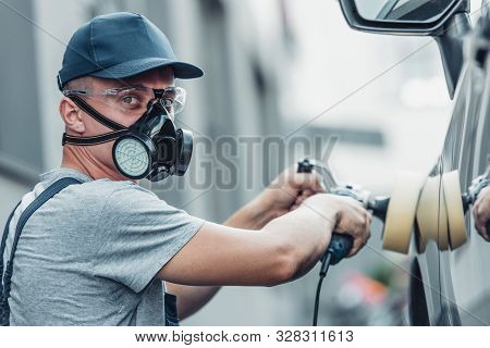 Young Car Cleaner In Respirator And Protective Glasses Polishing Car With Polish Machine