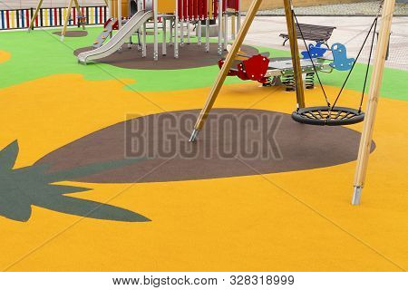 Empty Playground With Swings And Safe Rides With Anti-traumatic Bright Rubber Crumb Coating. Games F