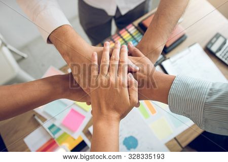 Close Up Of Group Of Business People Joining Their Hands Together In Unity.