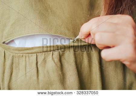 Young Woman Unzip Natural Linen Green Nursing Cloth Pulling Pawl At The Pocket At Bearst By Hand, Ha