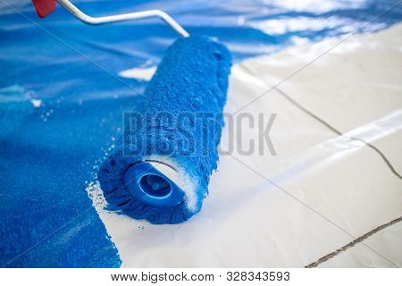Paint Roller With Blue Paint On Plastic Foil - Preparation Of A Football Choreography By Supporters