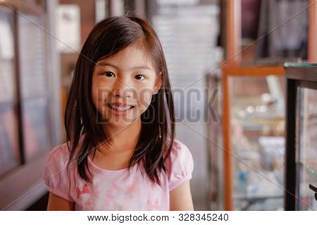 An Attractive Happy Asian Girl (thai) With Long Hair Smiling Brightly At An Antique Shop With Blur B