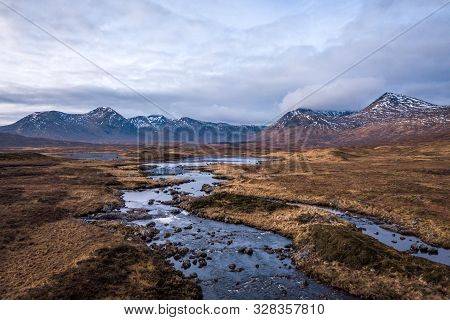 Scottish Highland Streams With Low-hanging Clouds Over Looking Black Mount Mountain Range On A Parti