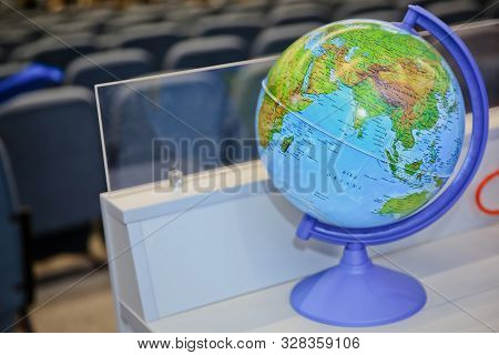 Businessman Using A Laptop With Close Up On World Globe. Global Concept. Blue Globe Against Blurred 