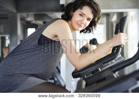 Sporty Woman Doing Excersice Bike Indoor At Fitness Gym. Healthy Sport Cardio Strong.
