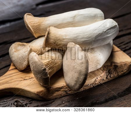 King oyster mushrooms on the wooden background.
