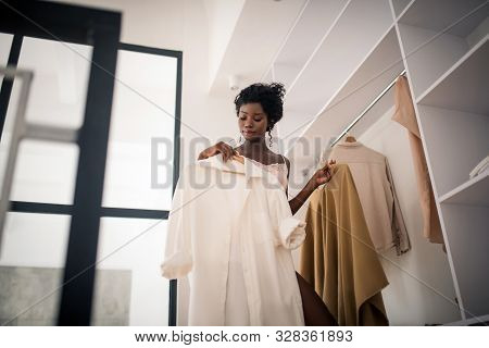 Curly Fashionable Woman Choosing Outfit For Day