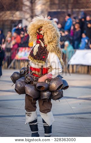 Mummers perform rituals to scare evil spirits at Surva festival at Pernik in Bulgaria. The people with the masks are called Kuker (kukeri). Mask from wool and big bells.
