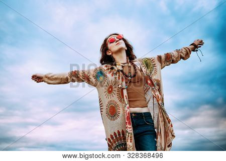 Fashion female model walking on a country road. Contemporary bohemian style. Spirit of freedom. Fashion shot. Bohemian, bo-ho style.