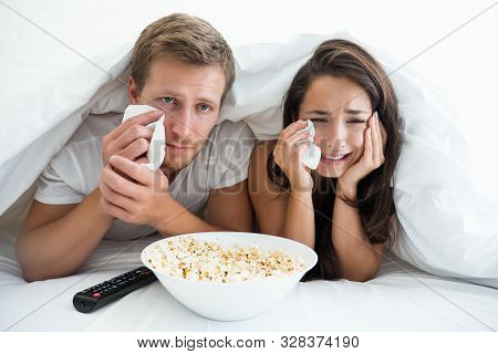 Young Couple Handsome Man And Beautiful Woman Watching Melodrama In Bed Eating Pop Corn Feeling Pitt