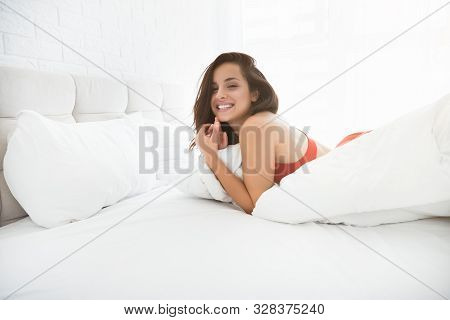 Young Attractive Happy Woman In Red Sexy Underwear Lying In Bed In Bright Bedroom Smiling