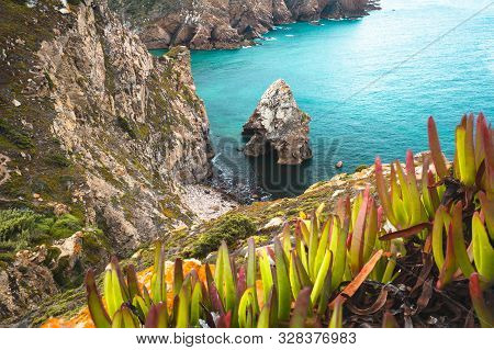 Cabo Da Roca Is The Extreme Point Of Europe. Hidden Beach With Rock, Blue Clear Waters And Foliage. 