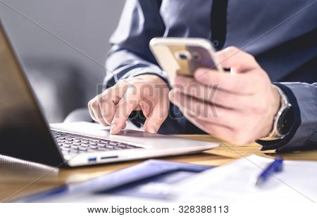 Multitasking And Mobile Technology. Busy Workaholic Business Man Using Phone And Laptop. Entrepreneu
