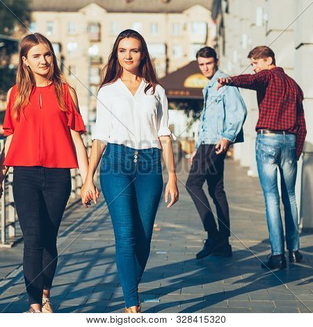 Sexual Tolerance. Judgement Mockery Shame. Men Staring At Lesbian Women Walking Holding Hands.