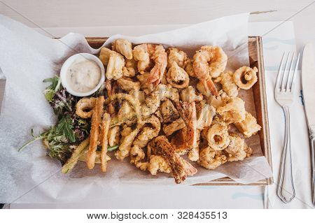 Frito Misto (varied Battered Deep Fried Seafood) Served On A Wooden Tray In A Restaurant, Selective 