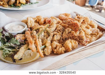 Frito Misto (varied Battered Deep Fried Seafood) Served On A Wooden Tray In A Restaurant, Selective 