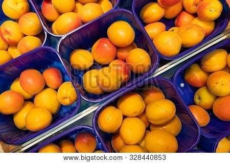 Yellow Fresh Delicious Plum In Blue Plastic Boxes At Food Market. May Be Used For Agriculure Backgro