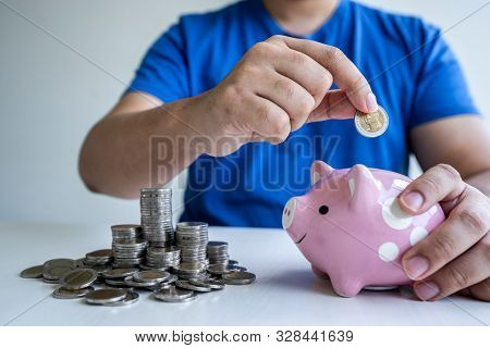 Man Putting Coins To Planning Growing Saving To Strategy With Piggy Bank For Future Plan Fund Of Tra