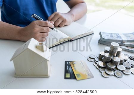 Man Writing Report To Planning Growing Saving To Strategy With Money Box For Future Plan Fund Of Tra