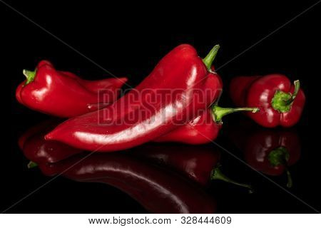 Group Of Four Whole Sweet Red Bell Pepper Isolated On Black Glass