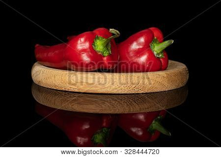 Group Of Two Whole Sweet Red Bell Pepper On Bamboo Plate Isolated On Black Glass
