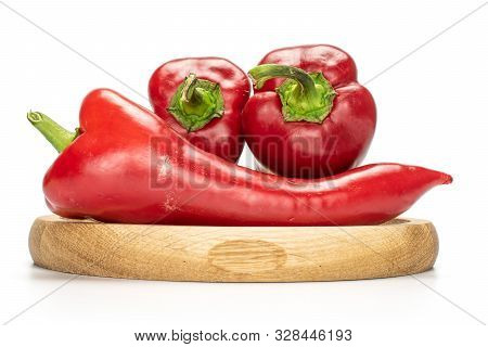 Group Of Three Whole Sweet Red Bell Pepper On Bamboo Plate Isolated On White Background