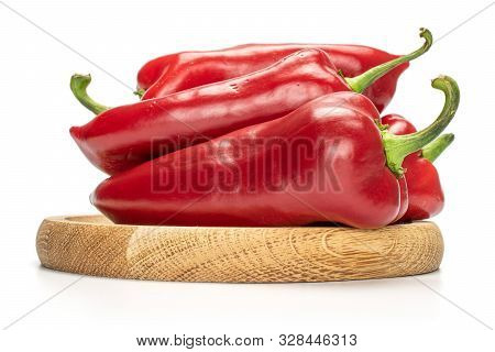 Group Of Four Whole Sweet Red Bell Pepper On Bamboo Plate Isolated On White Background
